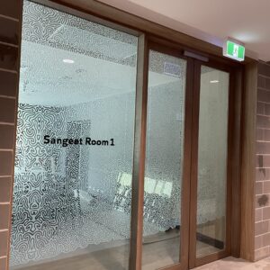 Privacy glass window with custom frosted design and lettering.