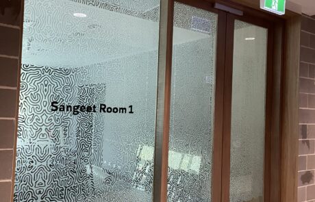 Privacy glass window with custom frosted design and lettering.