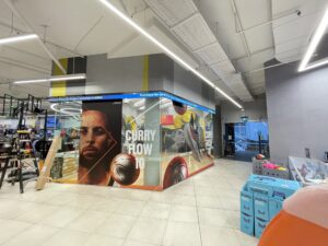 High-impact sports branding mural featuring Curry Flow 10 display.