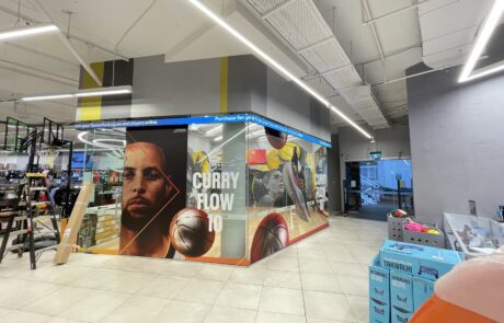 High-impact sports branding mural featuring Curry Flow 10 display.