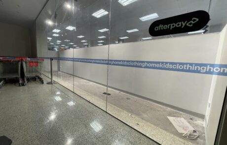 Minimalist retail store window signage featuring brand messaging.