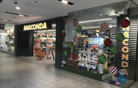 Anaconda retail store window signage with Christmas decorations.