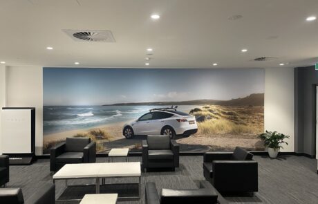 Tesla showroom interior with a scenic wall mural featuring a Tesla car.