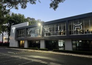 Illuminated Tesla LED signage on a modern commercial building, enhancing visibility and brand presence at dusk.