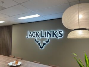 Backlit Jack Link’s reception sign in a modern office space, creating a professional and welcoming environment.