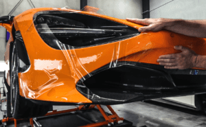 Paint protection film being applied to a Maclaren, ensuring long-term durability and a flawless finish.