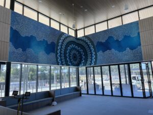 Custom wall mural in a modern commercial space with intricate blue patterns, designed for interior branding and office aesthetics.