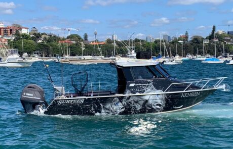 Custom boat wraps on the water with vivid marine graphic designs.