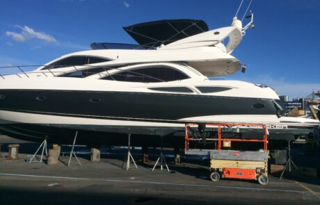 Boat wrap installation process on large yacht using elevated platform.